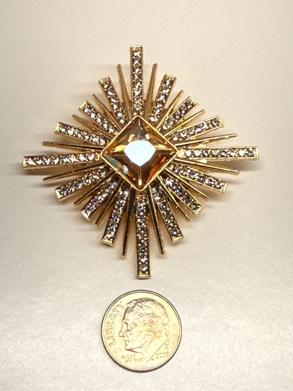 Sunburst Brooch with Rhinestones and Amber Stone measures 1.5" by 1.5"